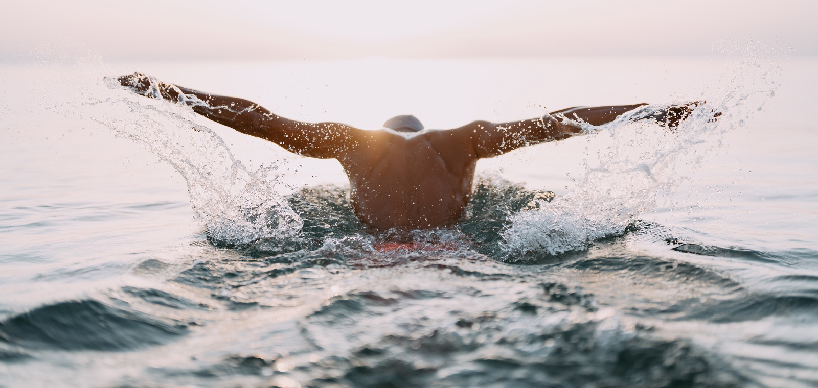 Photo of a young man who is having daily swim training in the sea